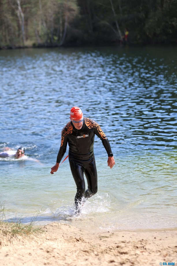 Jan Meier komt uit het water na het zwemmen bij een triathlon wedstrijd